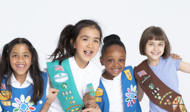 group of young girl scouts in uniform laughing